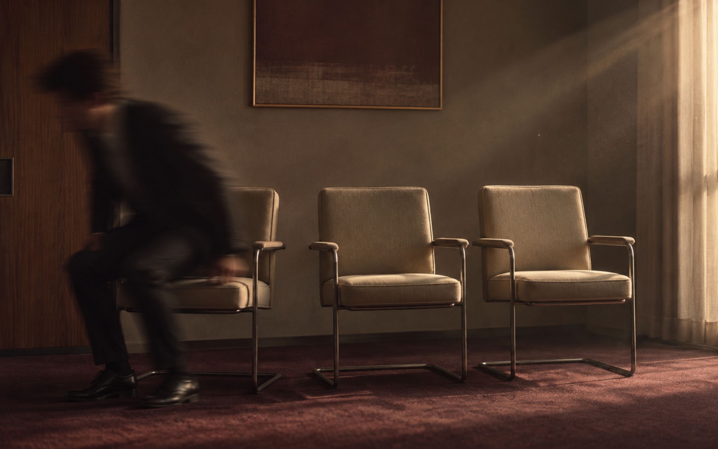 Three office chairs in a row, one occupied mid-departure, two empty, communicating repeated delegation failure.